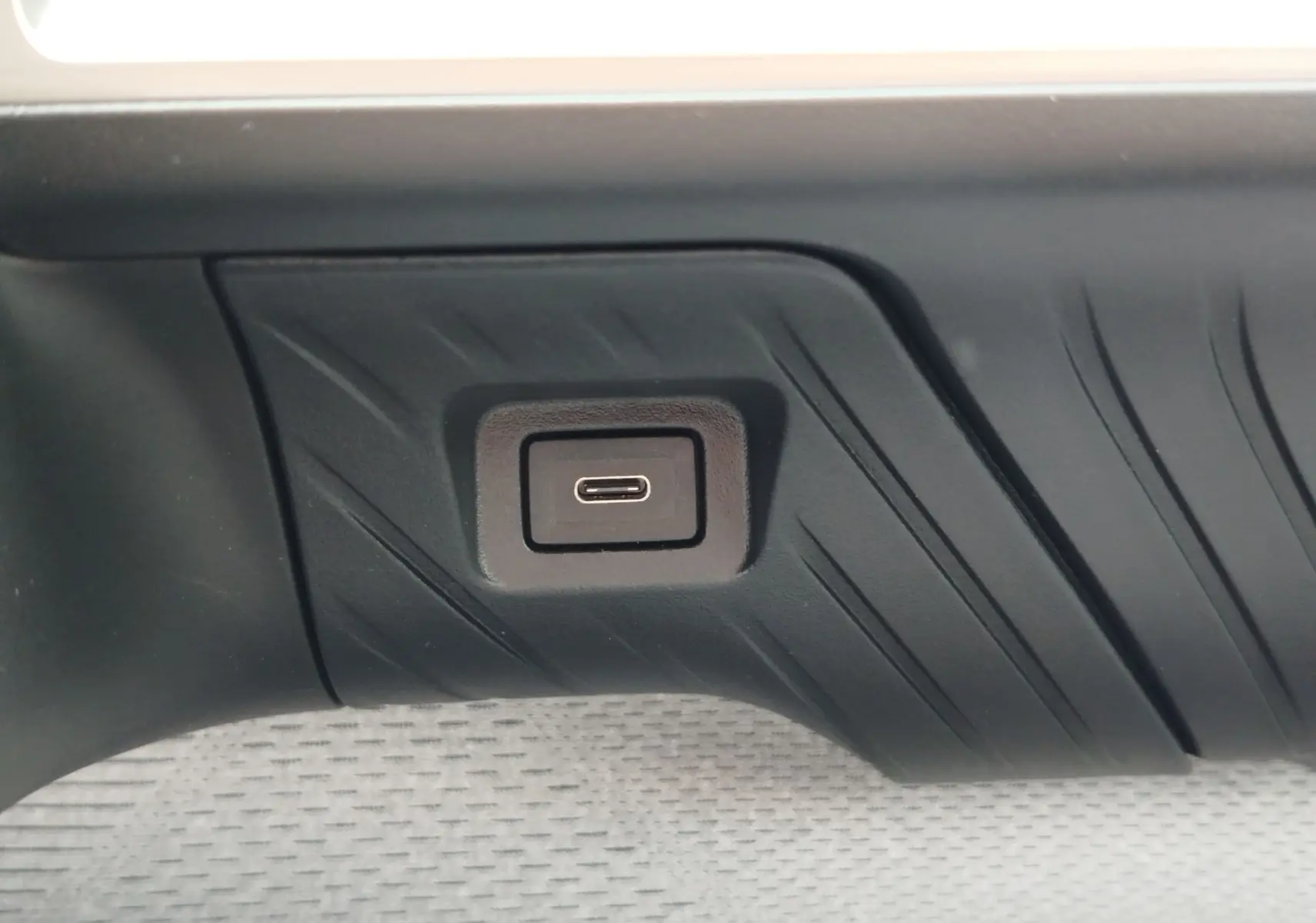 Prise USB-C intégrée dans la garniture intérieure noire d'une Citroën C3 2025, finition gris foncé.