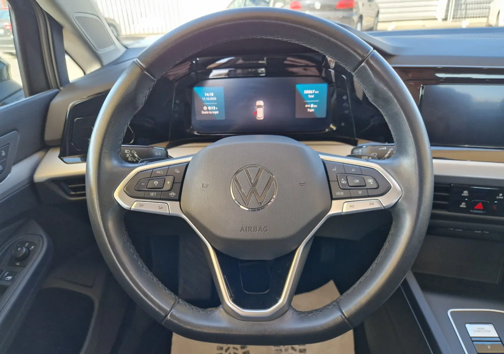 Vue rapprochée du volant noir de la Volkswagen Golf A8 2023 avec tableau de bord numérique et commandes intégrées.