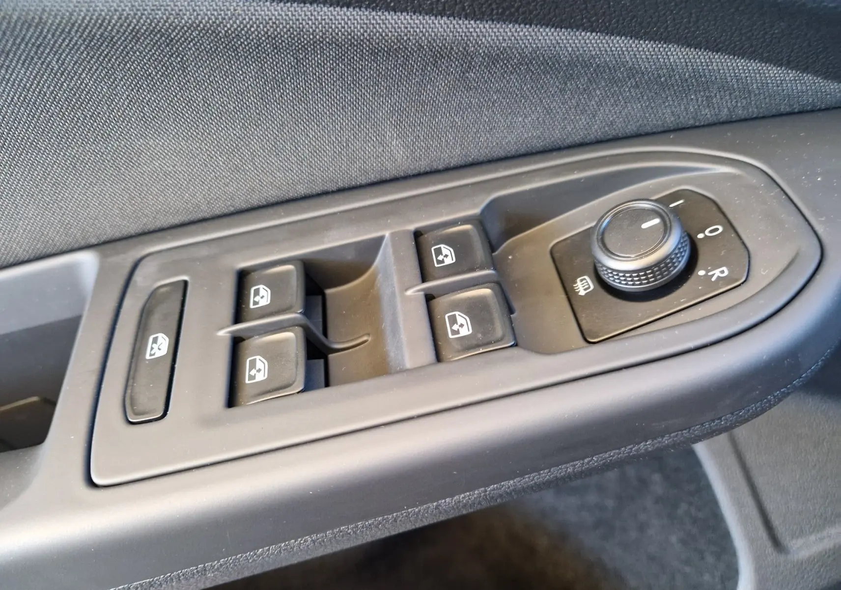 Commande des vitres électriques et réglage des rétroviseurs côté conducteur dans une Volkswagen Golf gris Urano 2023.