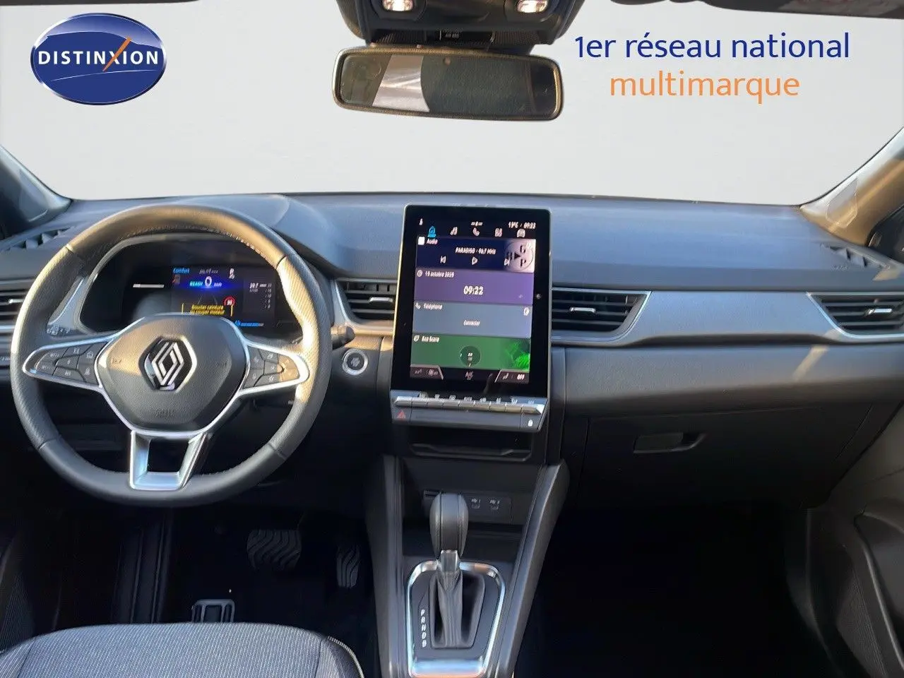 Vue intérieure du tableau de bord du Renault Captur E-Tech gris cassiopée, avec écran tactile vertical et volant multifonction.