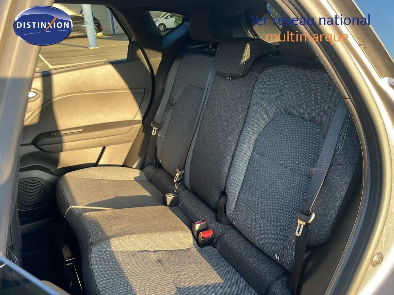 Vue intérieure arrière du Renault Captur gris cassiopée, mettant en valeur les sièges arrière en tissu gris foncé.