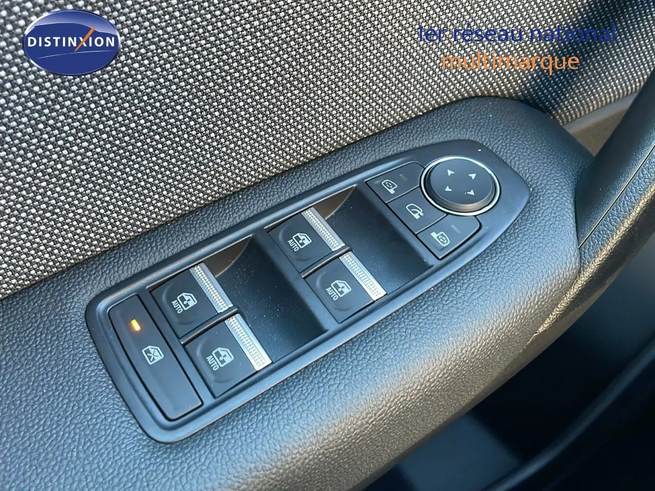 Gros plan sur les commandes des vitres électriques et rétroviseurs sur la portière côté gauche du Renault Captur gris cassiopée 2025.