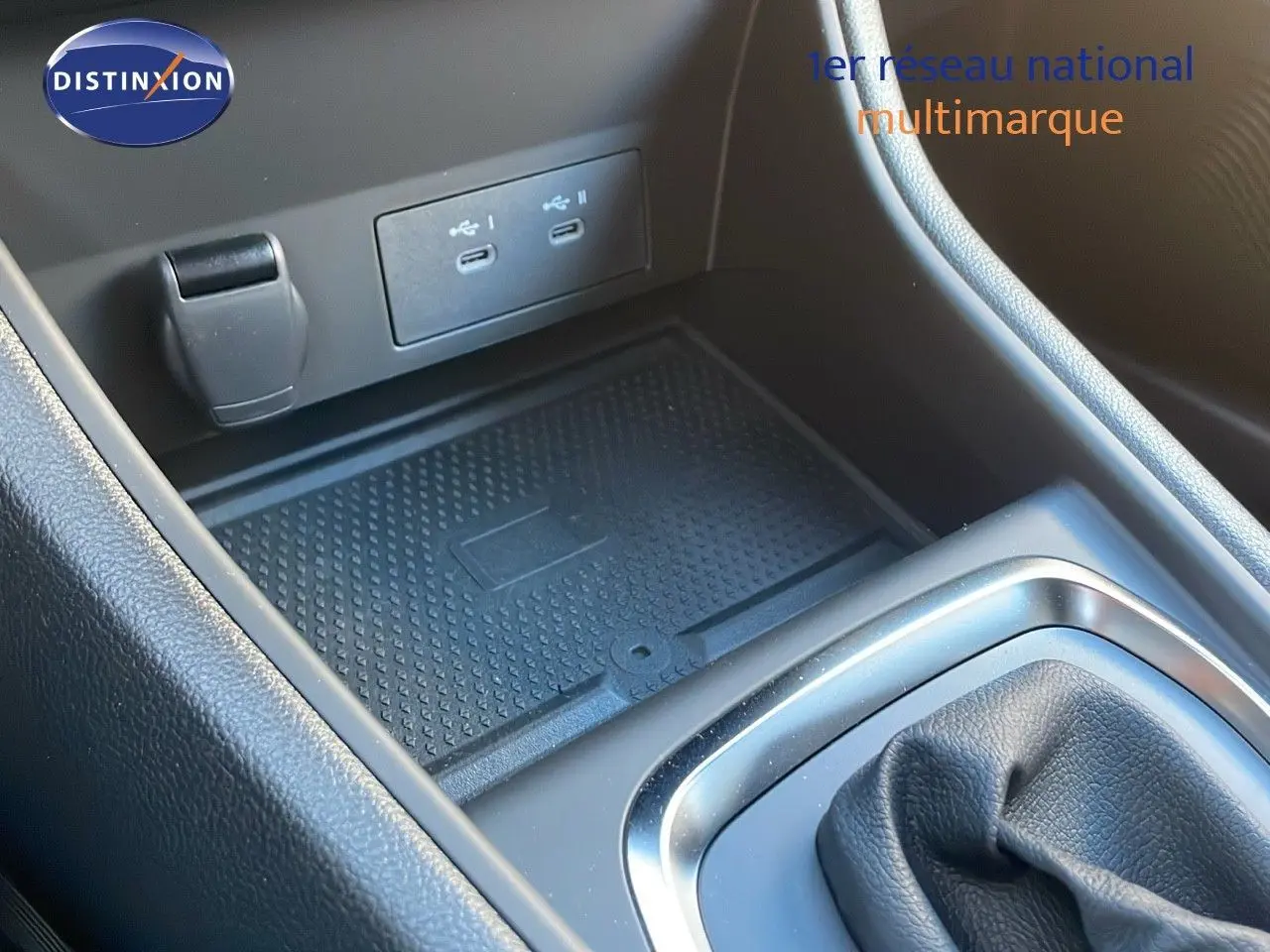 Gros plan sur la console centrale du Renault Captur gris cassiopée, montrant les ports USB et le rangement antidérapant.