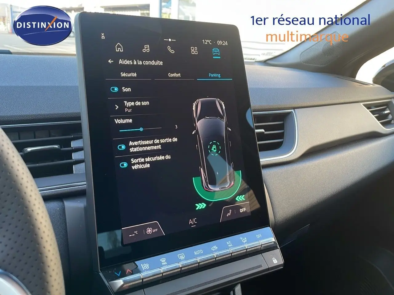 Vue intérieure du tableau de bord du Renault Captur E-Tech gris, avec écran tactile central affichant l'aide au stationnement.