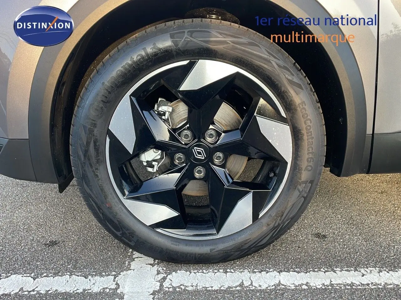 Gros plan sur la roue avant droite du Renault Captur gris Cassiopée Métal avec jante noire et argentée au design géométrique.