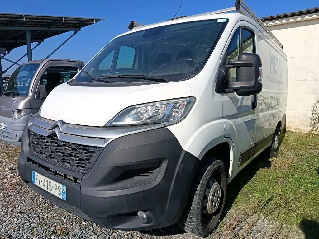 Vue 3/4 avant droit d'un utilitaire Citroën Jumper blanc 2020 avec galerie de toit et pare-chocs noir.