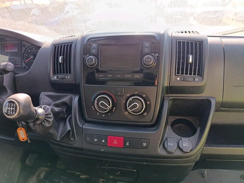 Tableau de bord du Citroën Jumper blanc 2020, vue frontale centrée sur la console avec commandes manuelles et écran éteint.