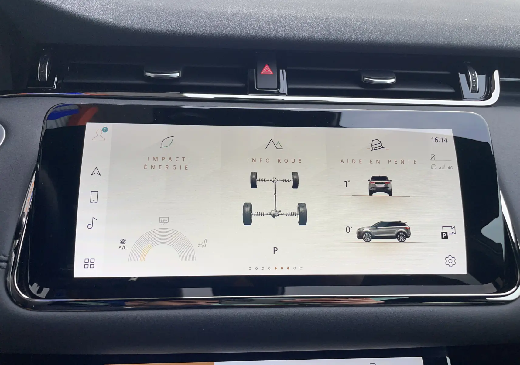 Gros plan sur les commandes de régulateur de vitesse au volant noir perforé du Range Rover Evoque gris Eiger, intérieur moderne.