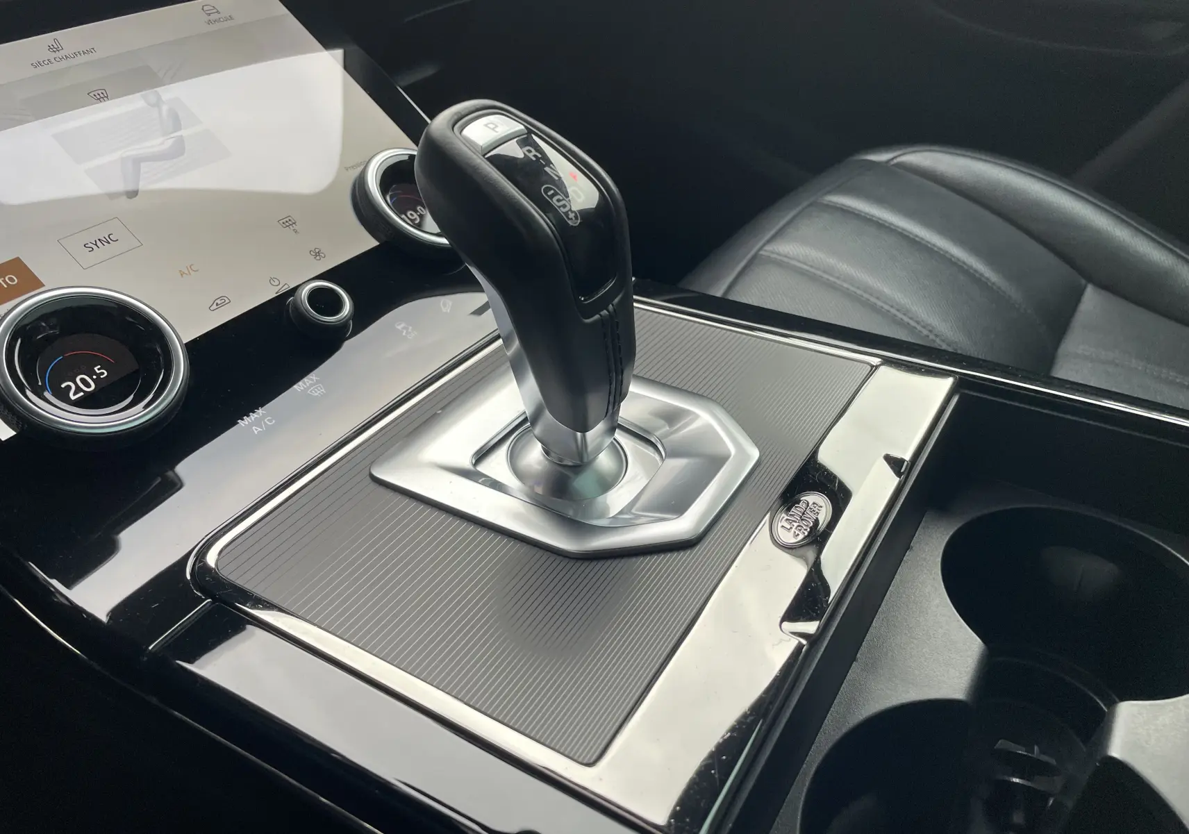 Gros plan sur les commandes de réglage électrique du siège avant d’un Range Rover Evoque 200D SE R-Dynamic gris.