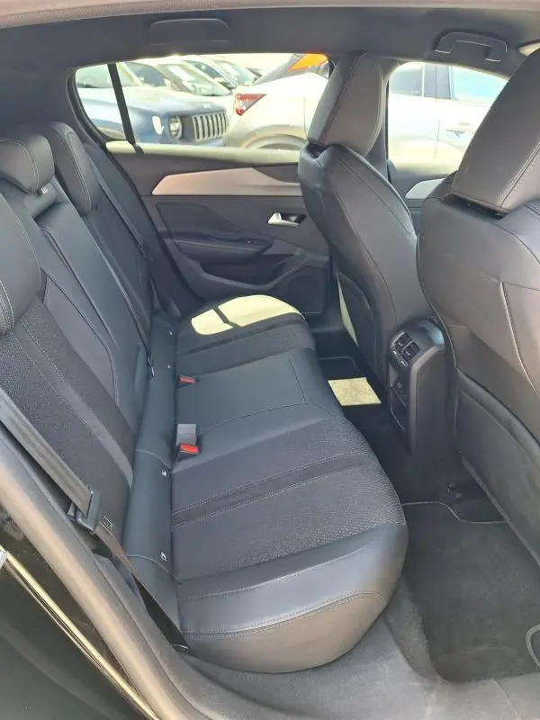 Vue intérieure côté droit des sièges arrière noirs en tissu et cuir du Peugeot 308 Hybrid 145 e-DCS6 GT 2025.