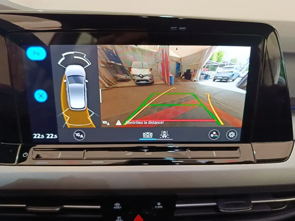 Écran tactile central affichant la caméra de recul et l’aide au stationnement de la Volkswagen Golf noire 2023.