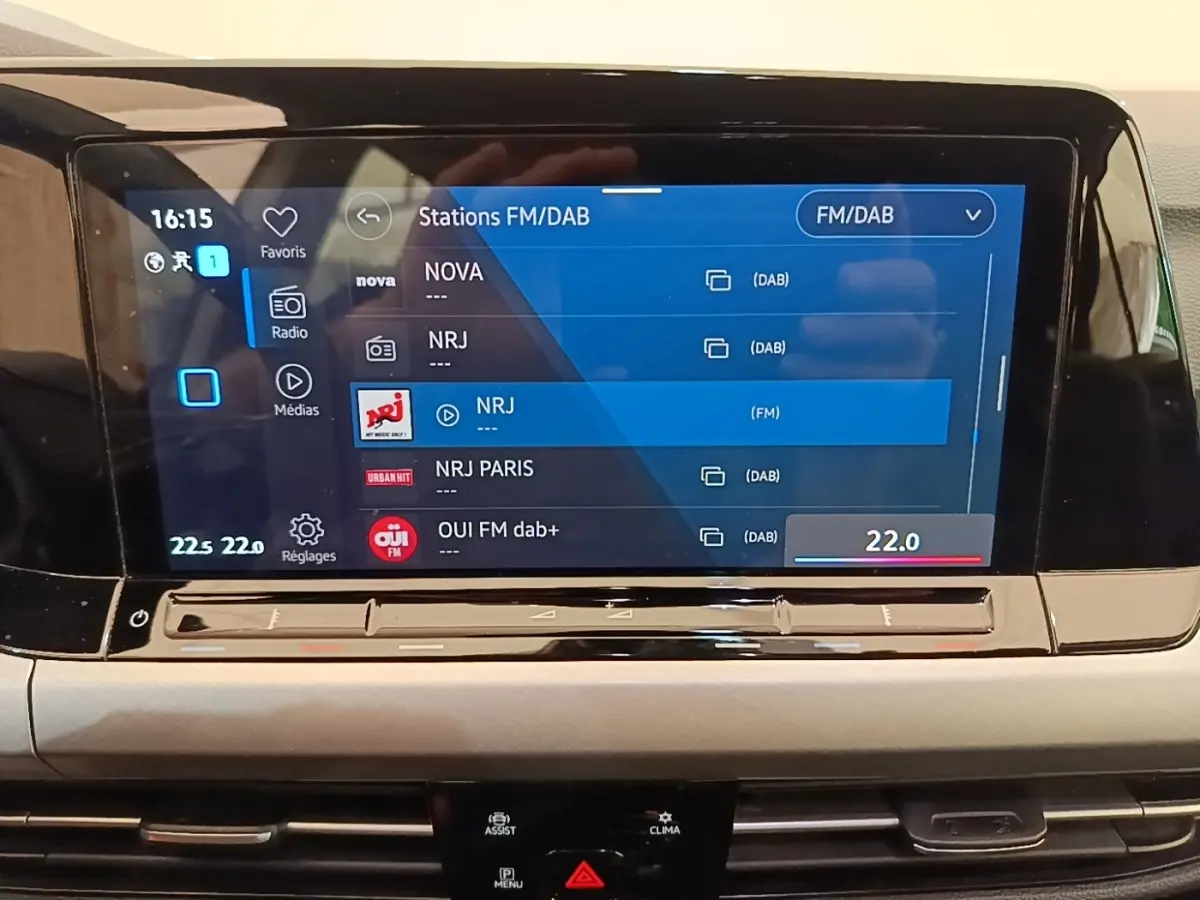 Écran tactile central affichant les stations radio FM/DAB dans l’habitacle d’une Volkswagen Golf noire 2023.
