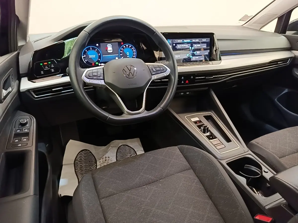 Intérieur de la Volkswagen Golf 2.0 TDI 2023, vue avant centrée sur le volant cuir et l’écran tactile noir.