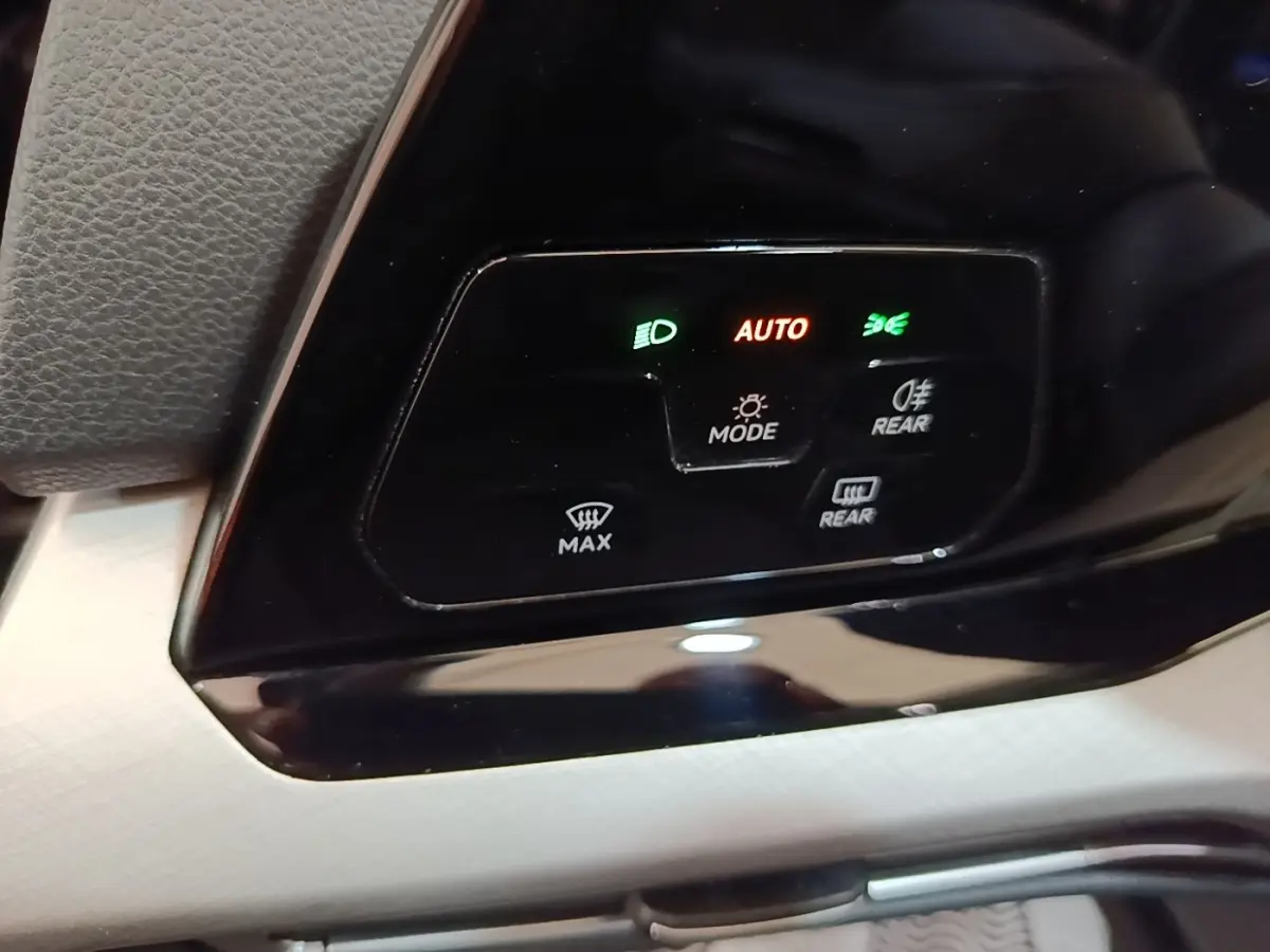 Détail du panneau de commande des feux et désembuage dans une Volkswagen Golf noire 2023, avec affichage lumineux.
