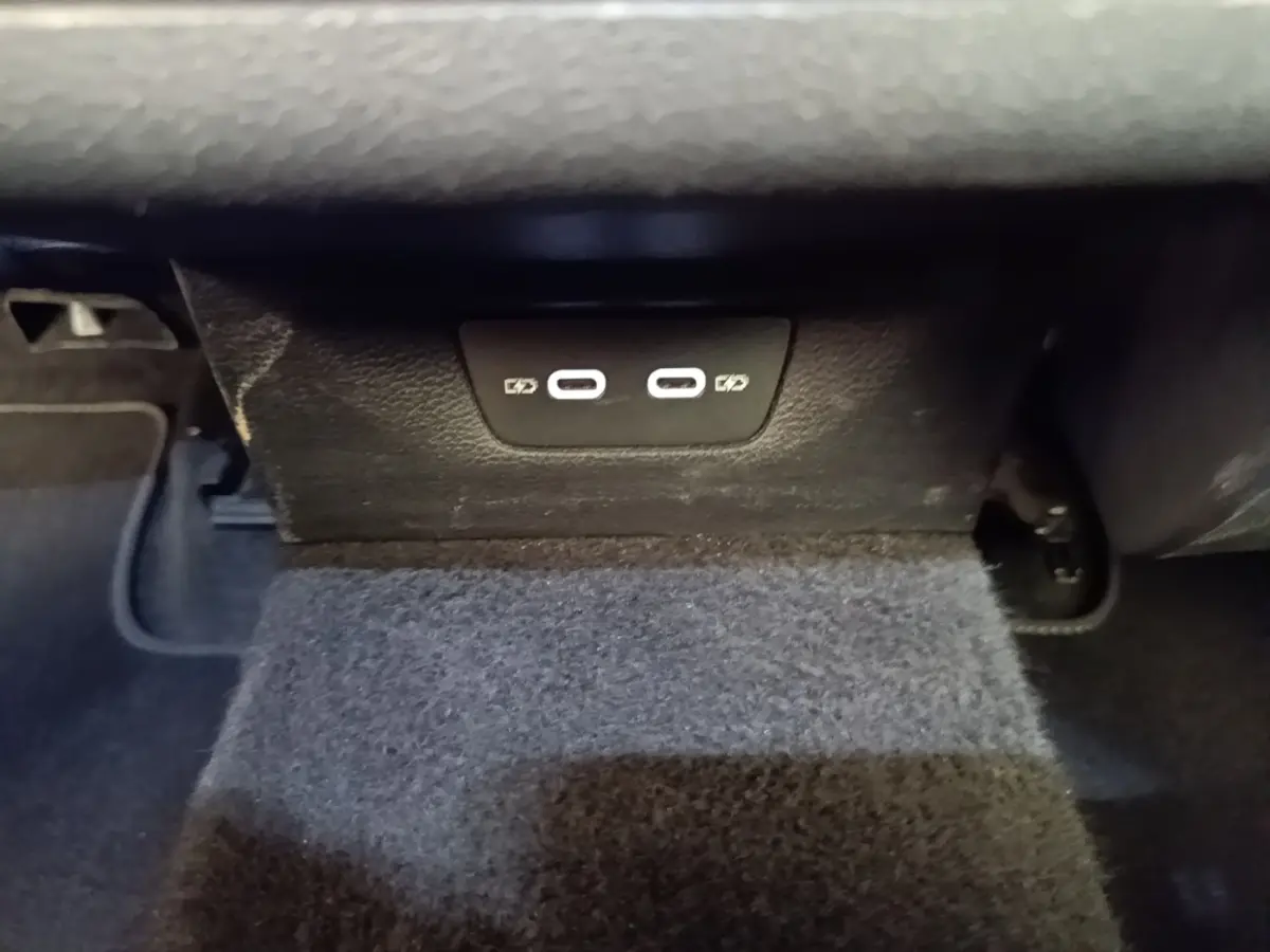 Vue rapprochée des ports USB-C de recharge situés sous le tableau de bord d'une Volkswagen Golf noire 2023.