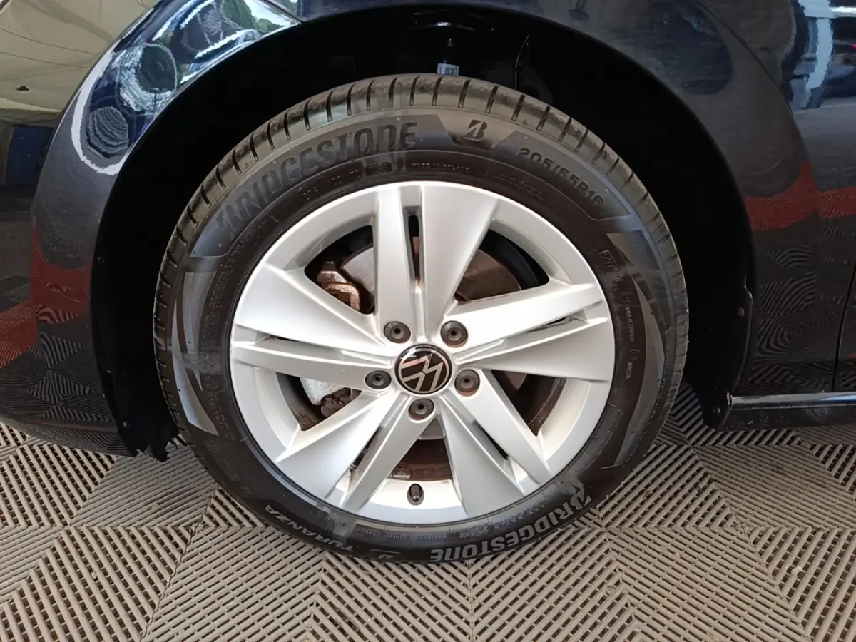 Gros plan sur la roue avant gauche argentée d'une Volkswagen Golf noire 2023 avec pneu Bridgestone.