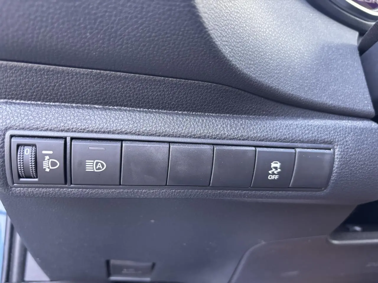 Gros plan sur les commandes noires du tableau de bord côté gauche de la Toyota Corolla hybride bleu clair 2020.