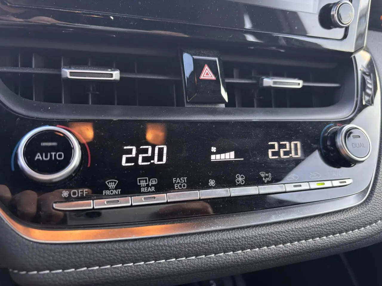 Détail du tableau de bord de la Toyota Corolla hybride 2020 montrant la climatisation automatique réglée à 22°C.