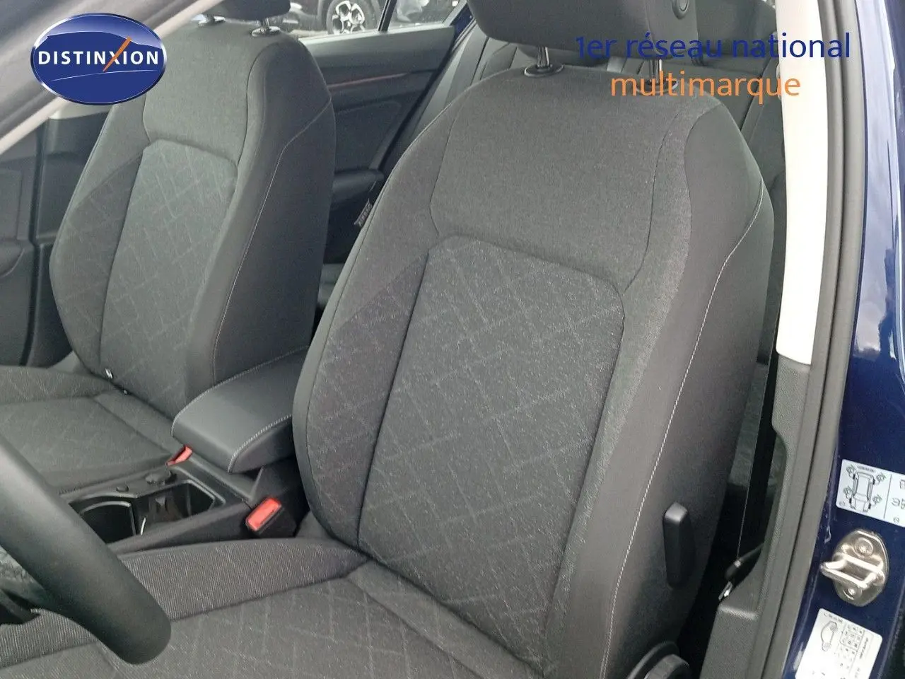 Vue intérieure rapprochée des sièges avant en tissu gris de la Volkswagen Golf VIII bleu Atlantique 2023.