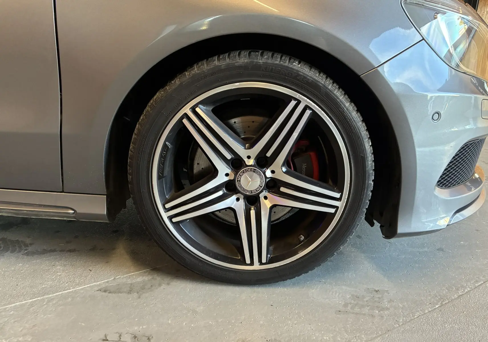 Gros plan sur la roue avant droite gris métallisé d'une Mercedes Classe A 250 AMG Sport avec jante alliage cinq branches.