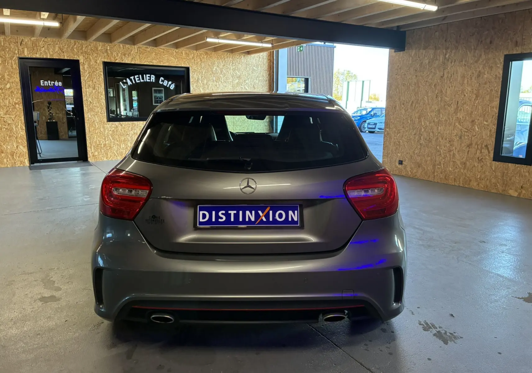 Vue arrière d'une Mercedes Classe A 250 AMG Sport gris métallisé, avec double sortie d'échappement et logo distinctif.