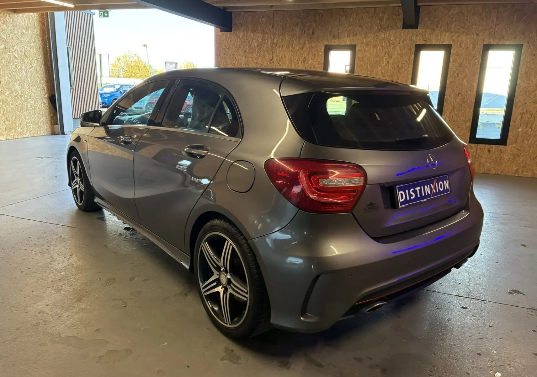 Vue 3/4 arrière droite d'une Mercedes Classe A 250 AMG Sport gris métallisé avec jantes AMG 5 branches bicolores.