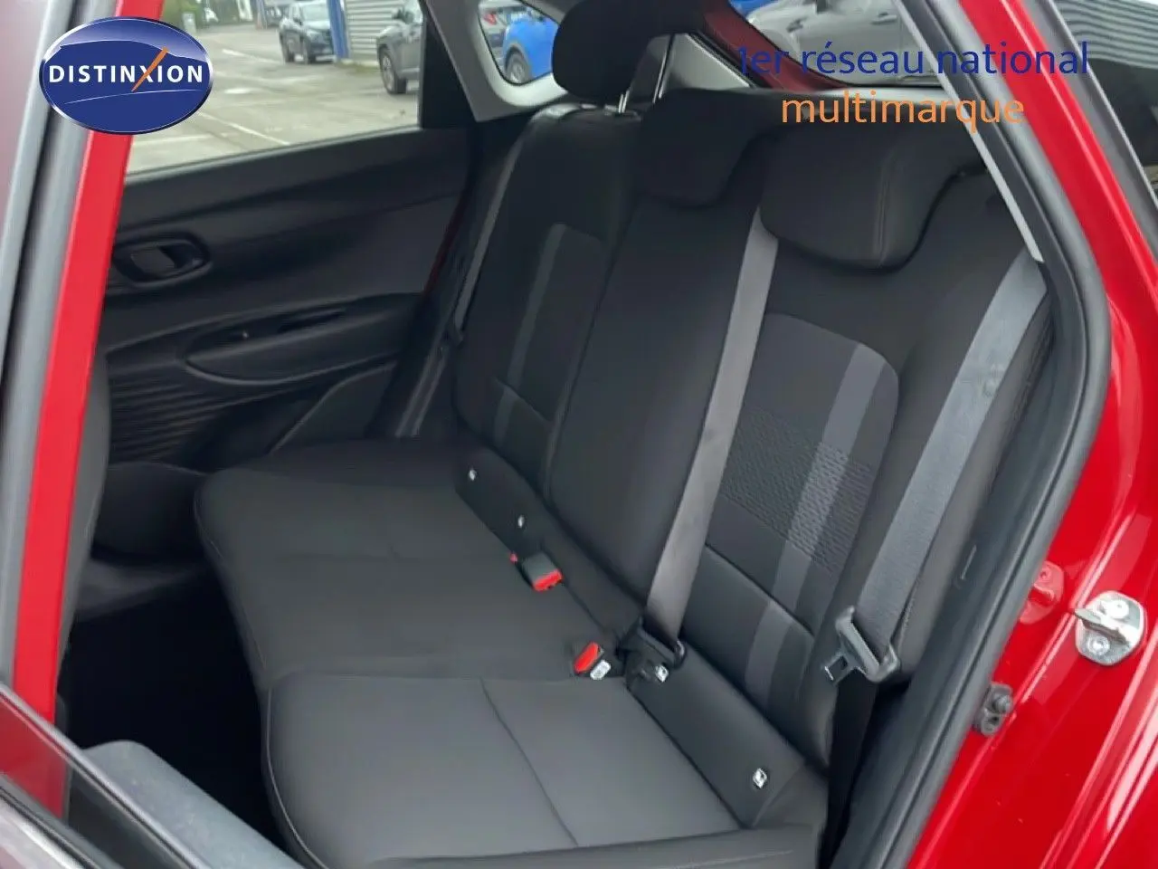 Vue côté droit de la banquette arrière noire d'une Hyundai i20 rouge Dragon Metal avec ceinture de sécurité visible.