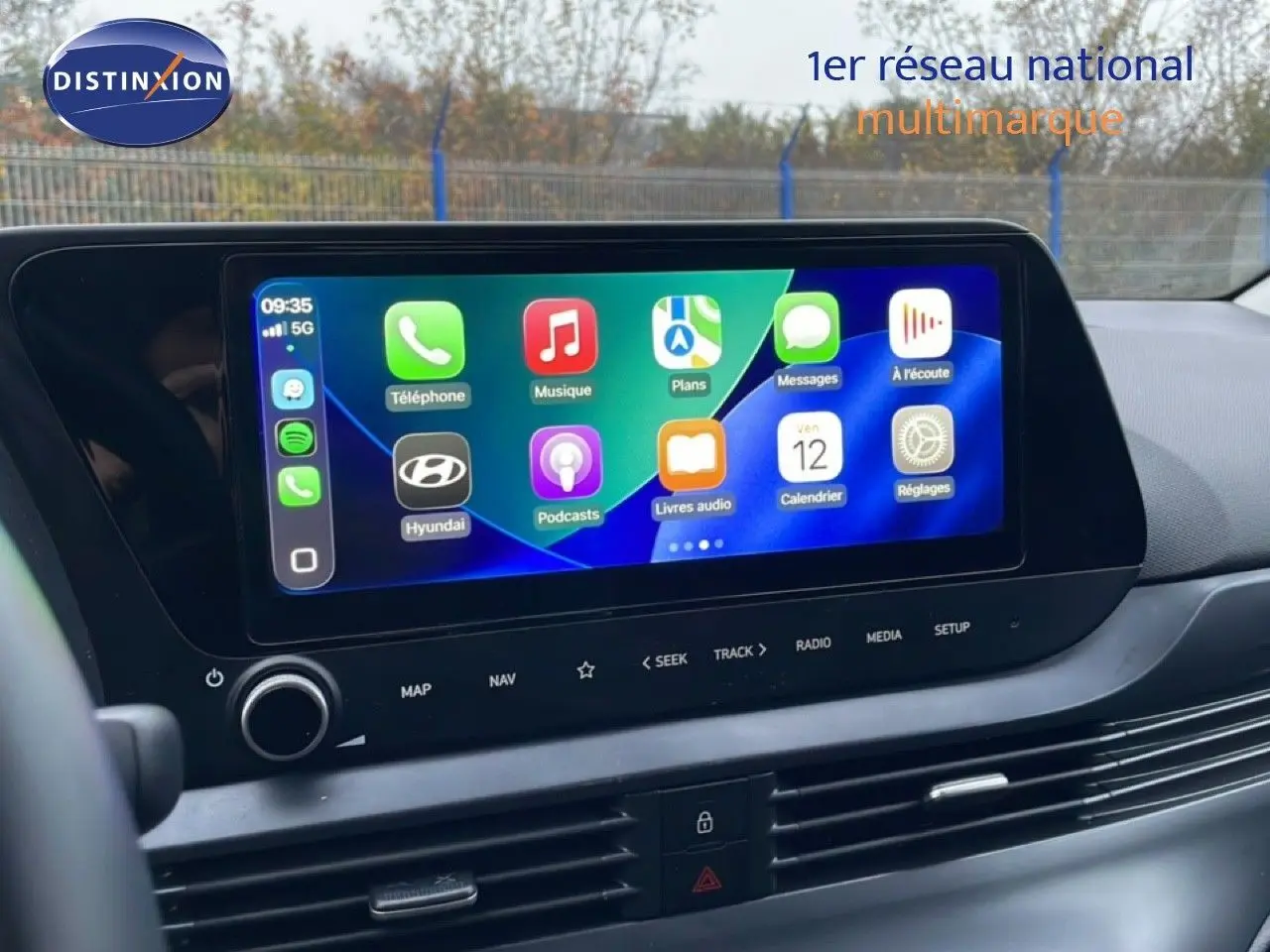 Écran tactile central allumé avec interface Apple CarPlay dans l'habitacle d'une Hyundai i20 rouge Dragon Metal.