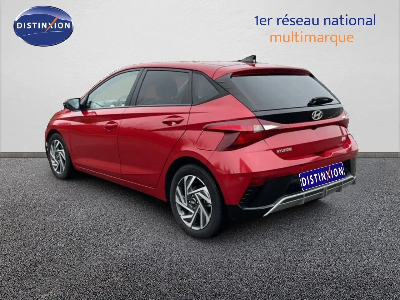 Vue 3/4 arrière droite d'une Hyundai i20 2025 rouge Dragon Metal avec feux LED et jantes alliage distinctives.