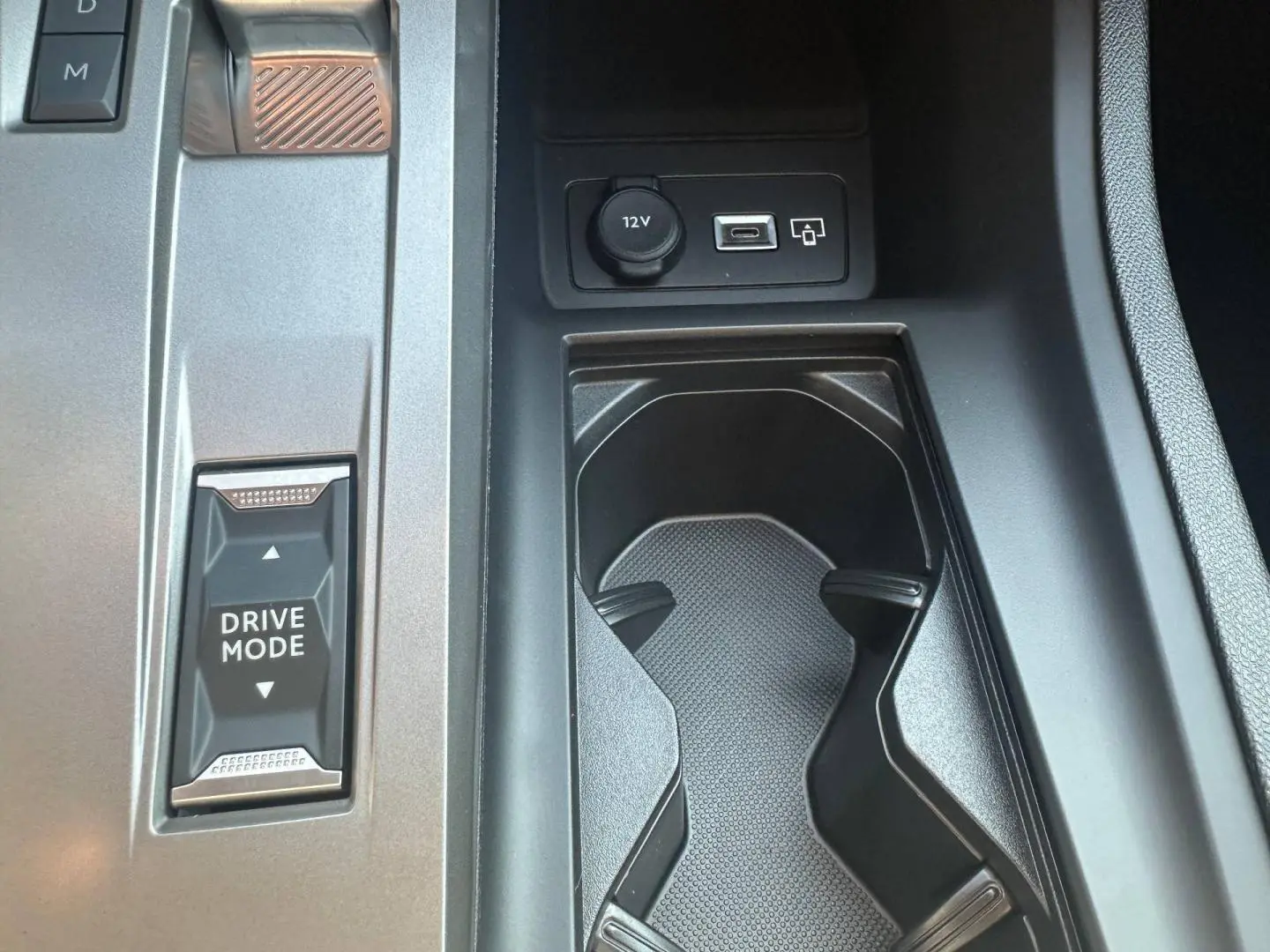 Gros plan sur la console centrale de la Peugeot 308 SW blanche, avec bouton Drive Mode et prises 12V et USB visibles.