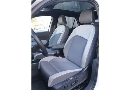 Vue intérieure côté conducteur du Volkswagen ID.3 blanc glacier, sièges avant gris clair avec réglages électriques et appuie-têtes.