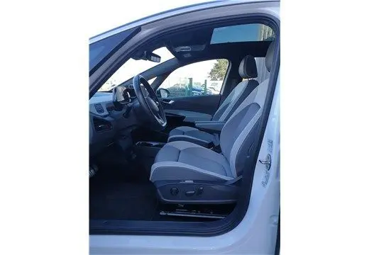 Intérieur côté conducteur d'un Volkswagen ID.3 blanc glacier 2020, montrant les sièges électriques et le tableau de bord moderne.
