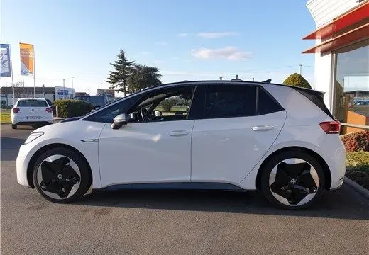 Profil latéral gauche d'un Volkswagen ID.3 blanc glacier électrique, avec jantes au design moderne et toit noir contrastant.