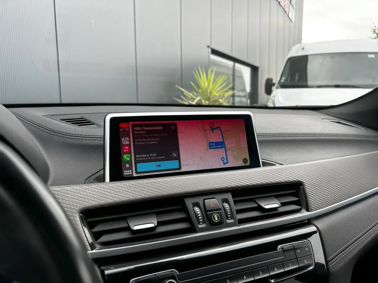 Vue rapprochée du tableau de bord de la BMW X2 F39, avec écran GPS affichant un itinéraire et détails de navigation.