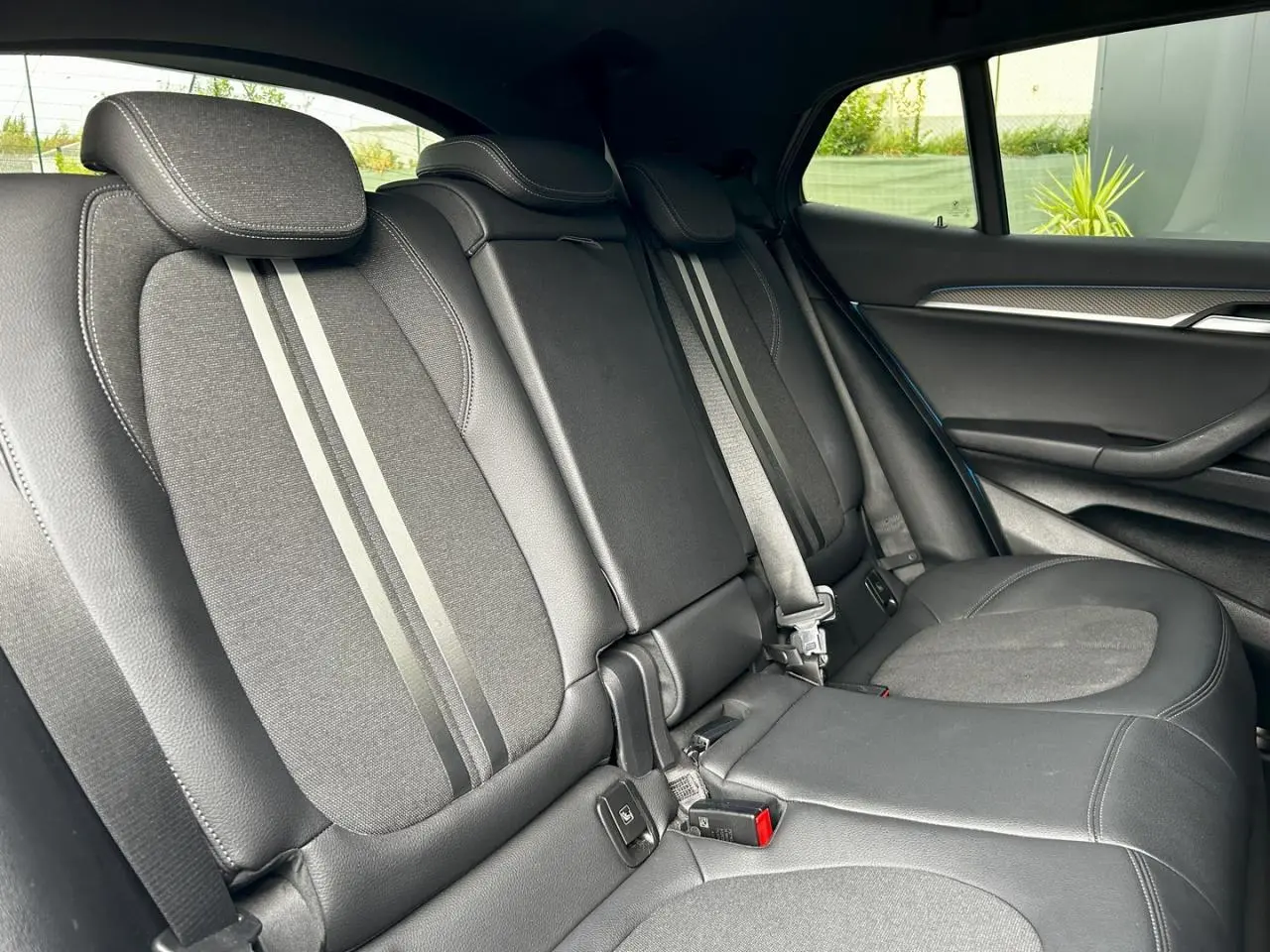 Vue latérale intérieure des sièges arrière en cuir noir et tissu avec surpiqûres contrastées du BMW X2 F39 2021.