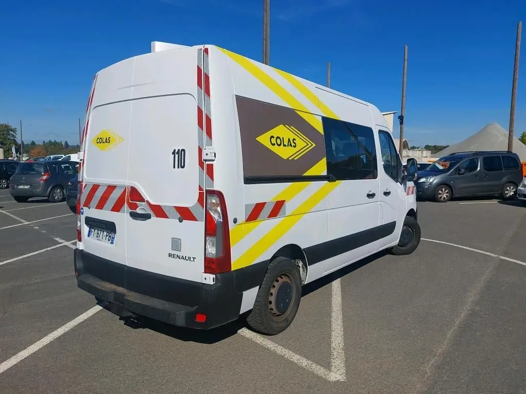 Renault Master cabine approfondie blanc, vue 3/4 arrière droit, marquages jaunes et rouges COLAS et gyrophare visible.