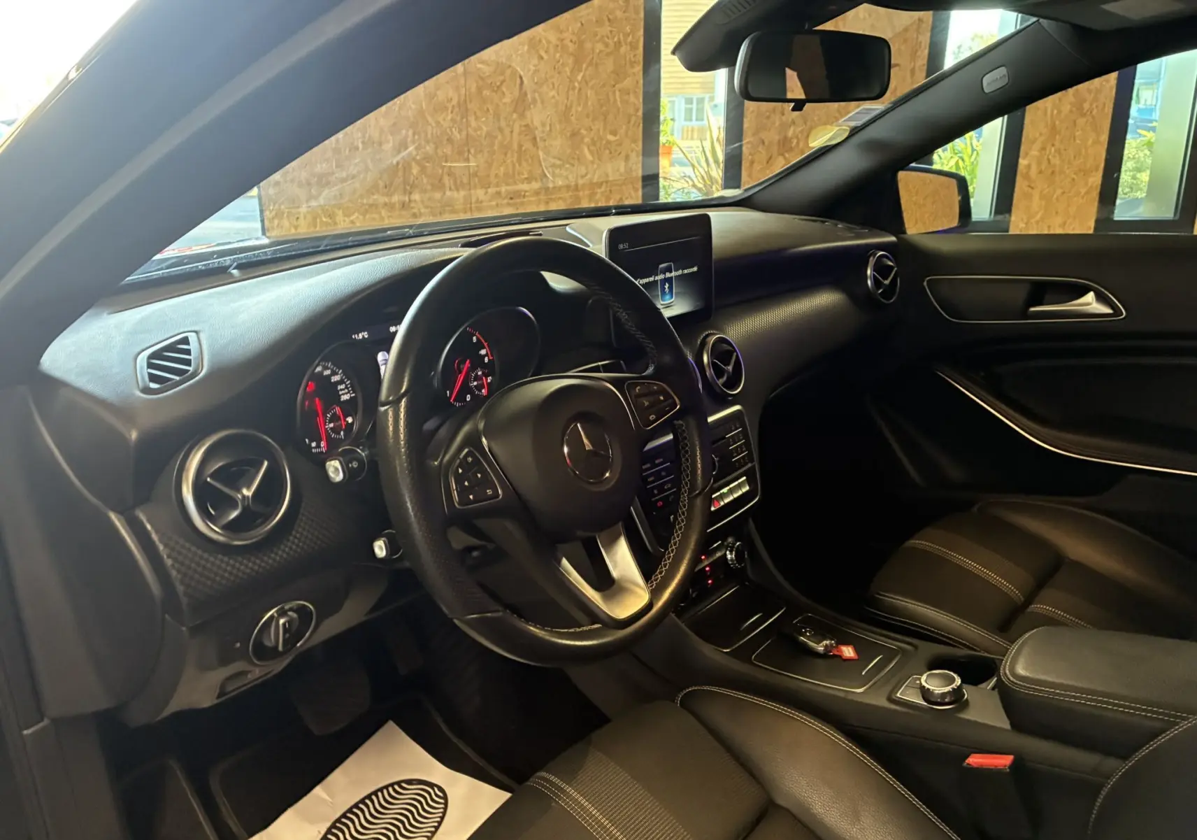 Intérieur noir de la Mercedes Classe A 180 CDI 2018, vue côté conducteur sur le tableau de bord et volant cuir.