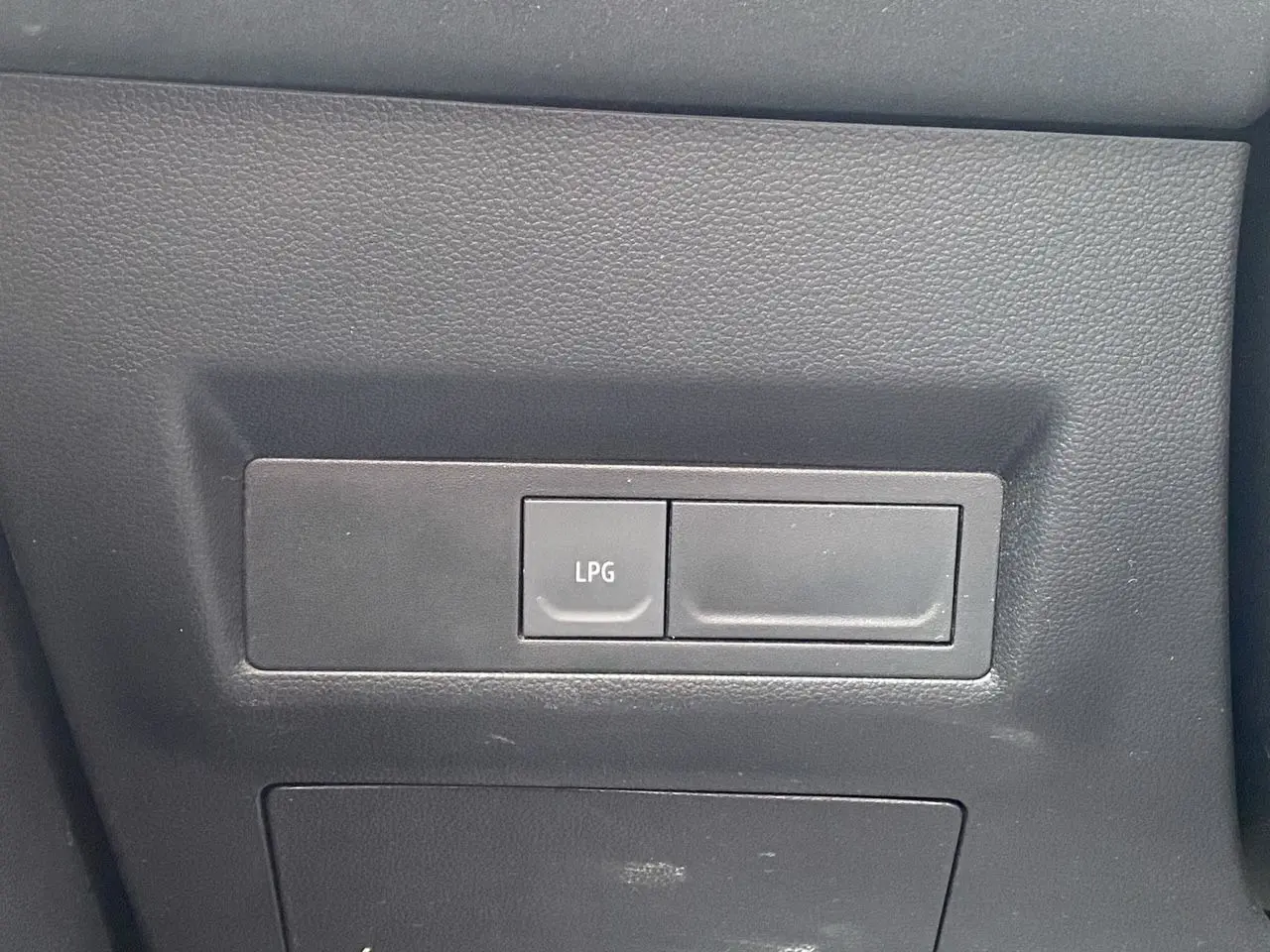 Gros plan sur le bouton LPG dans l’habitacle noir du Renault Captur Gris Cassiopée toit noir.