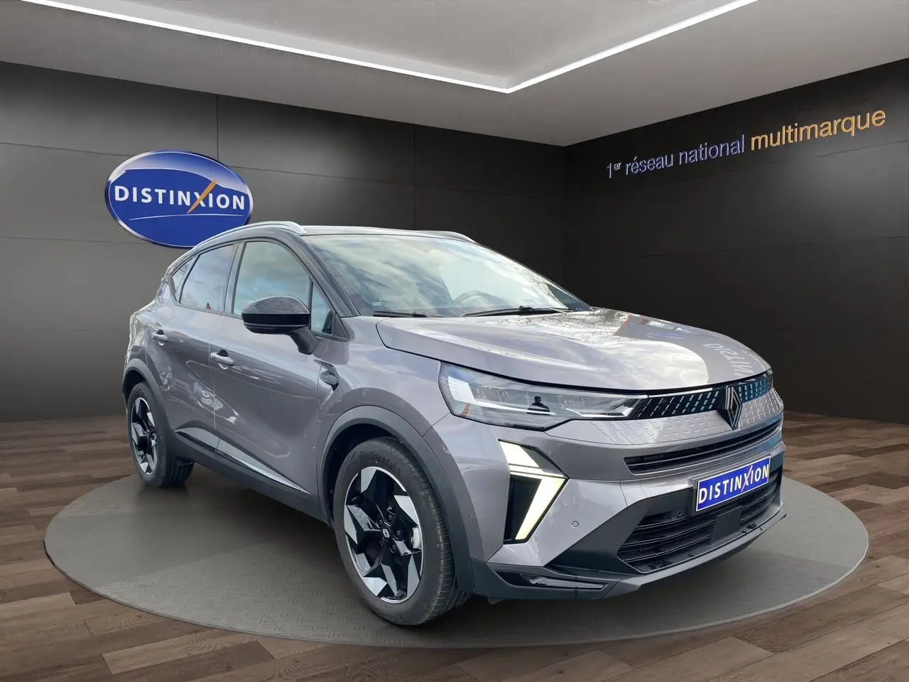 Renault Captur Eco-G 100 Techno gris cassiopée avec toit noir, vue 3/4 avant, barres de toit et jantes alu 18 pouces.