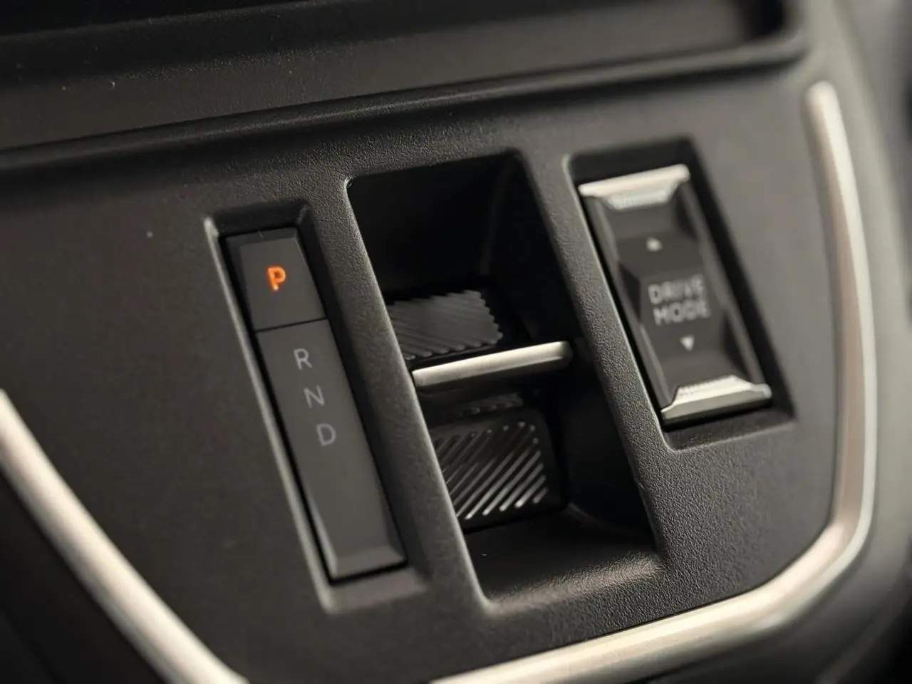 Gros plan sur la console centrale noire du Citroën Jumpy XL 2025 avec bouton de boîte auto et mode de conduite.