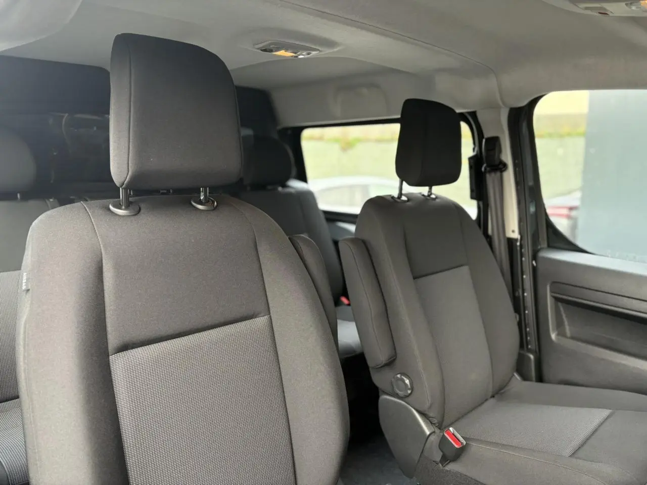 Vue intérieure côté droit des sièges avant en tissu bi-ton noir et gris du Citroën Jumpy XL 2025.