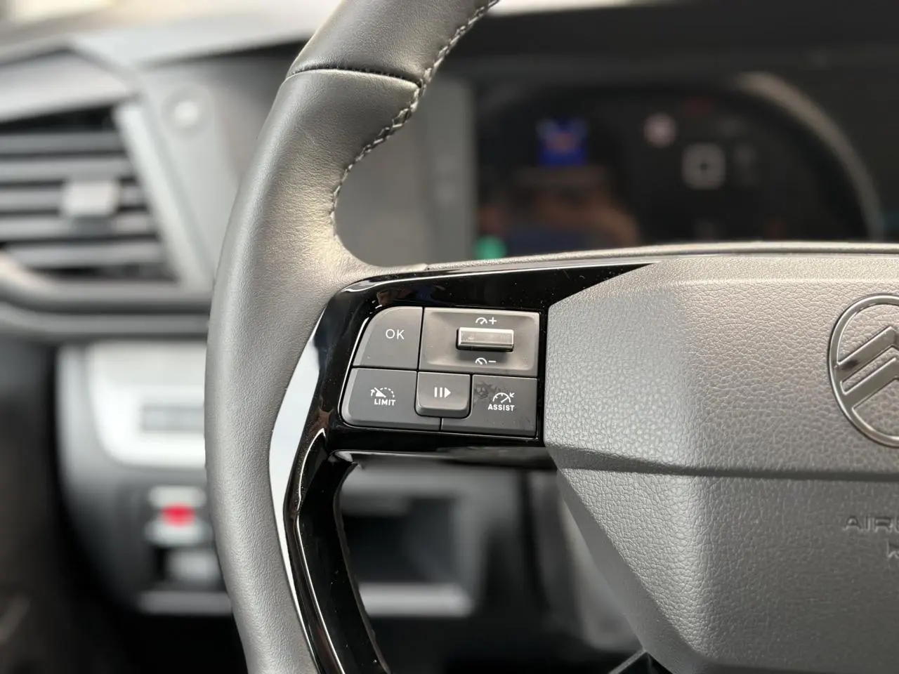 Gros plan sur le volant cuir gris du Citroën Jumpy avec commandes intégrées et logo central visible.