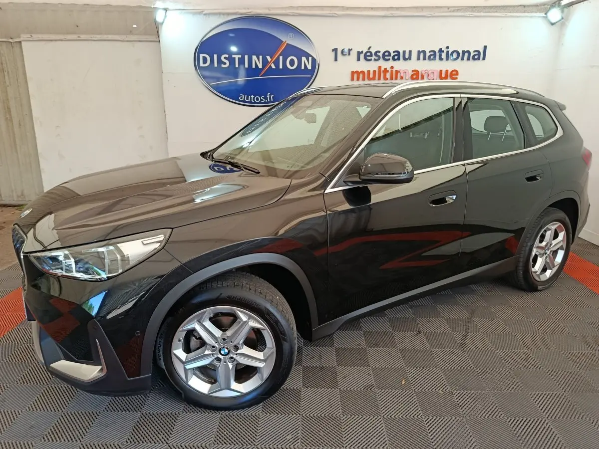 BMW X1 sDrive18i noir en 3/4 avant droit, avec jantes alliage et rétroviseurs rabattables électriquement.