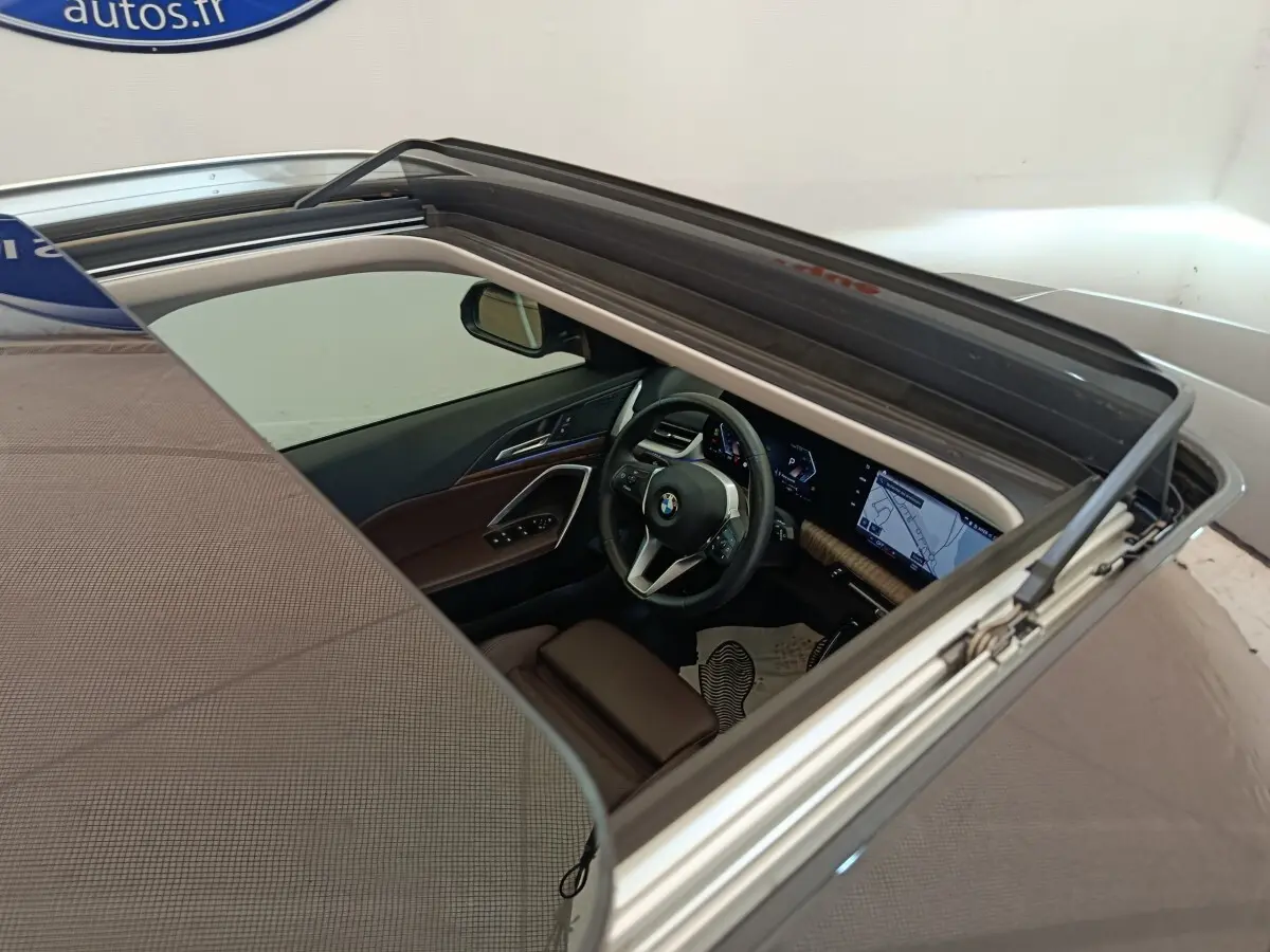 Vue plongeante sur l'intérieur cuir marron et le tableau de bord avec écran tactile du BMW X1 noir 2023.