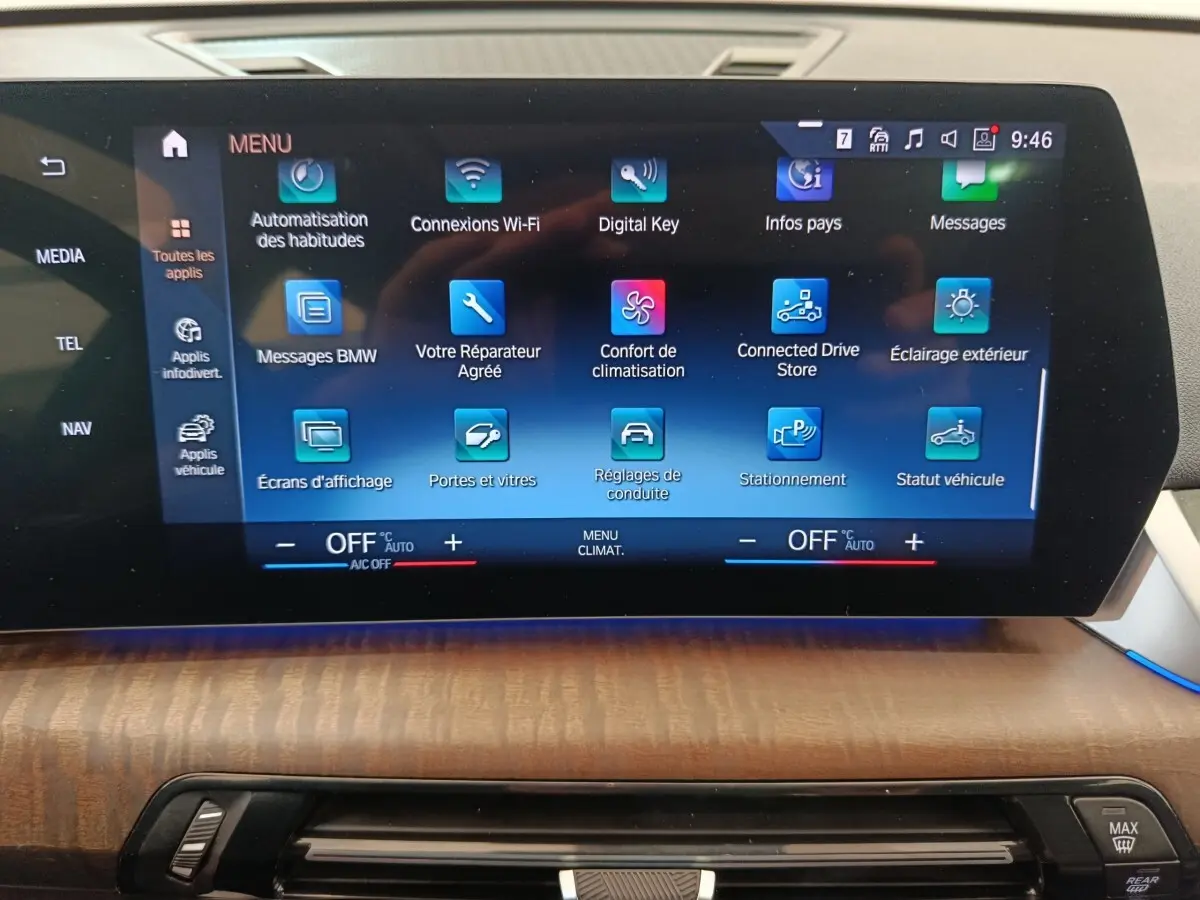 Écran tactile central du tableau de bord du BMW X1 noir, affichant le menu des applications connectées.