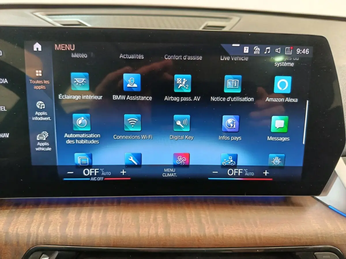 Écran tactile central du tableau de bord du BMW X1 2023 affichant le menu des applications et réglages climatisation.