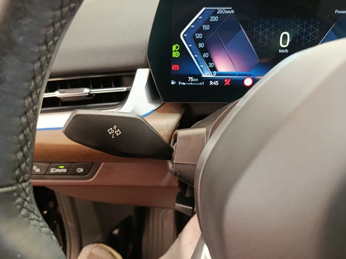 Détail du combiné d'instruments digital et levier de clignotant côté gauche sur BMW X1 sDrive18i 2023 noir.