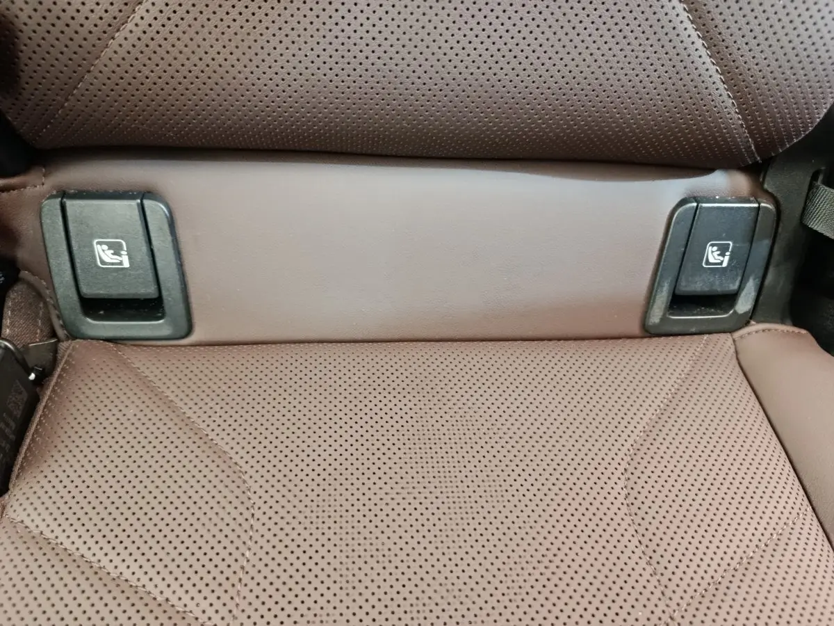 Gros plan sur la banquette arrière en cuir marron perforé du BMW X1 sDrive18i Business Design 2023 avec fixations Isofix visibles.