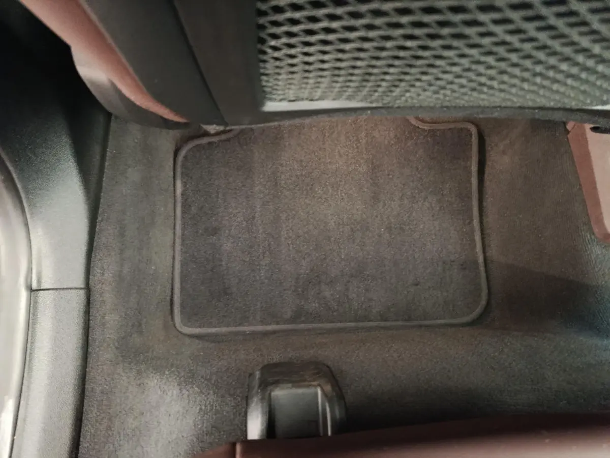 Détail du tapis de sol noir côté passager avant du BMW X1 sDrive18i 2023, intérieur sobre et propre.