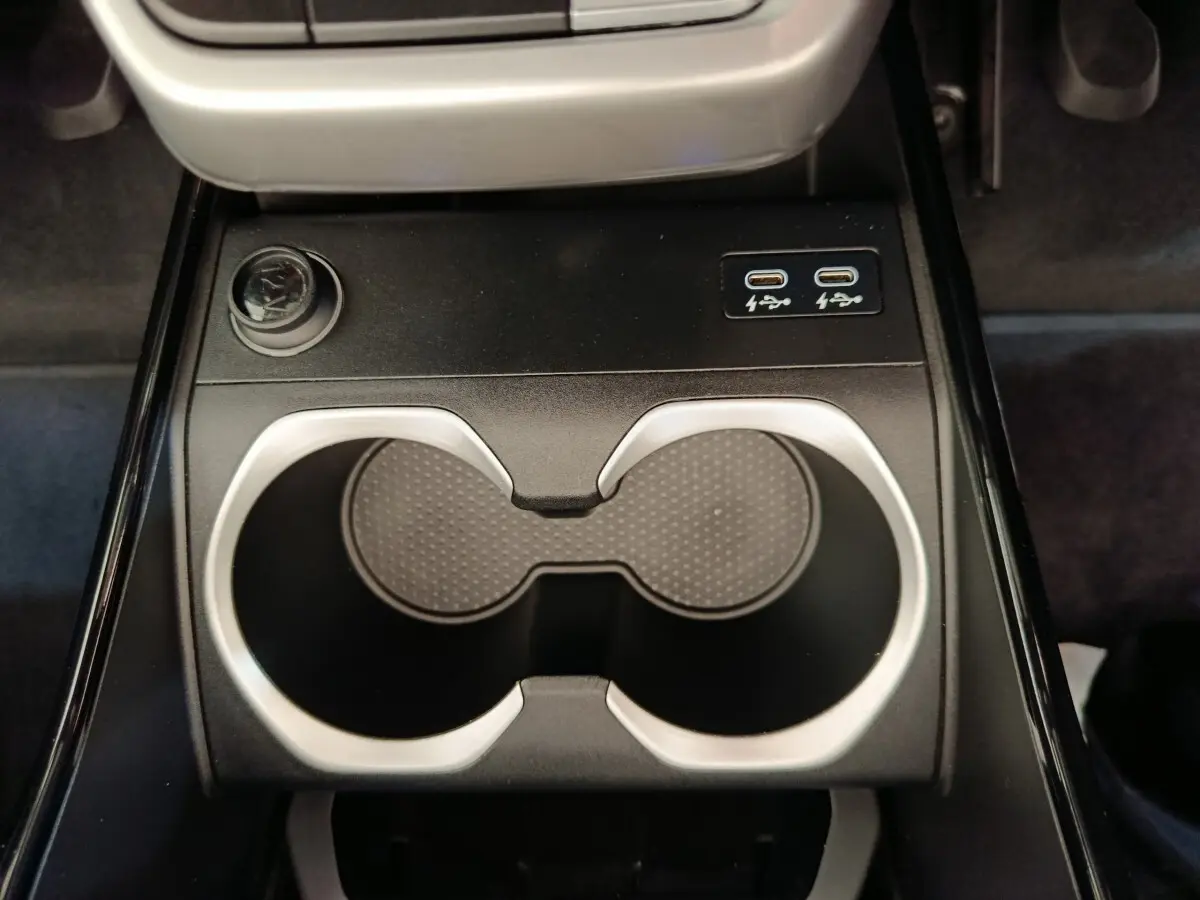 Gros plan sur les porte-gobelets et ports USB-C de la console centrale du BMW X1 sDrive18i Business Design 2023 noir.